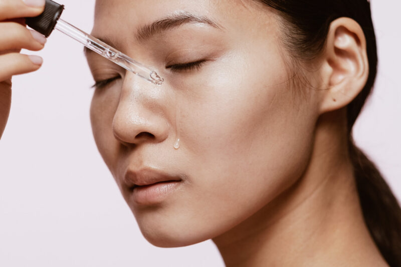 Woman applying serum on her face