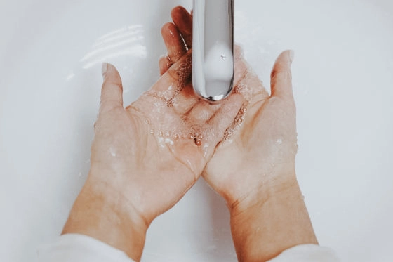 Woman washing her hands to prepare for cleansing her face