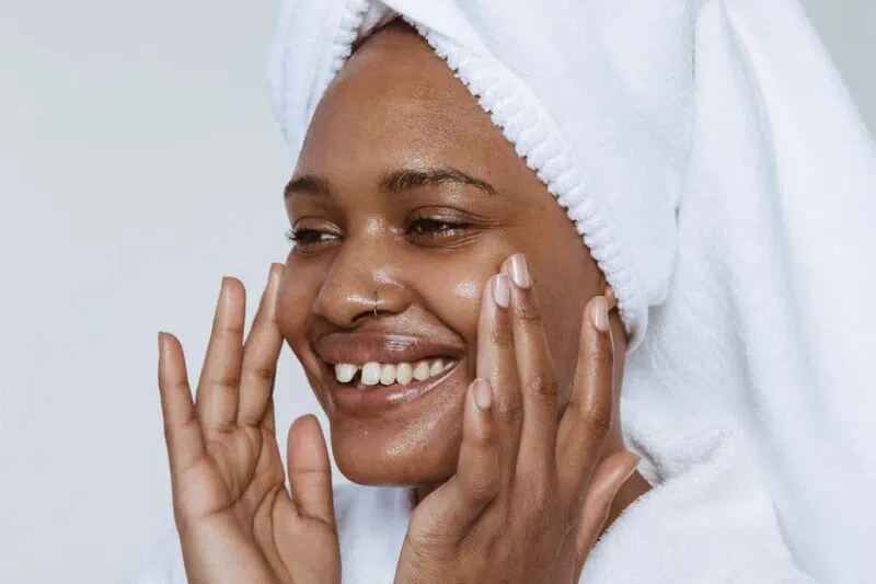 Woman applying serum and smiling