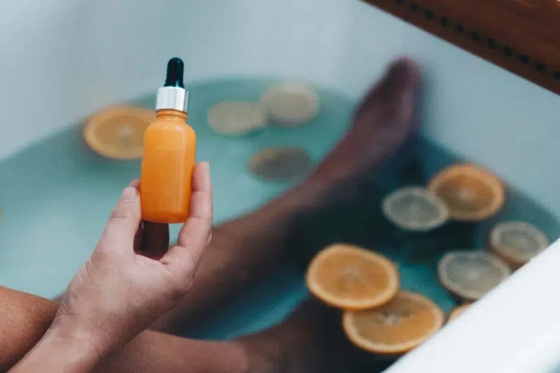 Woman holding serum in bathtub