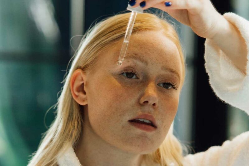 Woman putting serum on her face