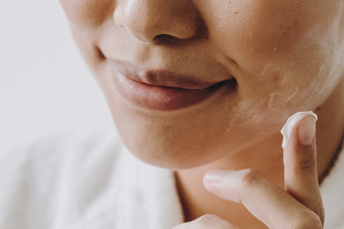 Woman applying night cream to skin.