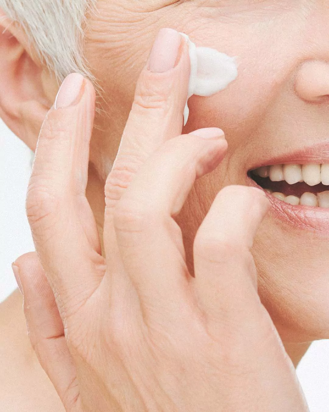 Woman applying sunscreen to her face