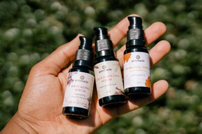Woman holding three bottles of 15 ml Annmarie Skin Care signature line serums