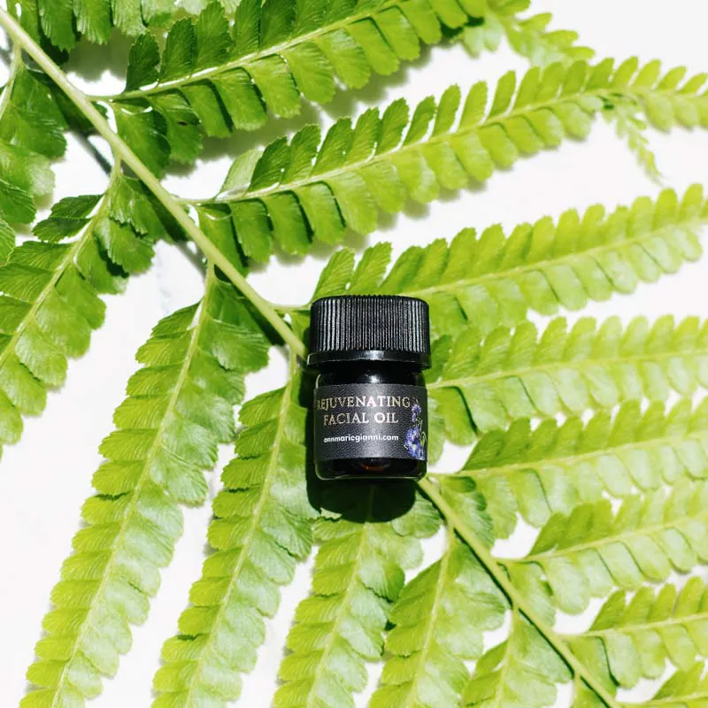 Rejuvenating Facial Oil on a fern leaf background