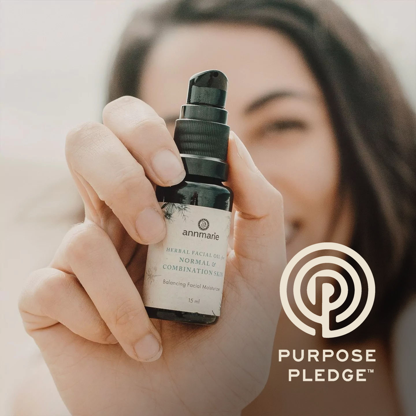 Woman holding Annmarie Skin Care Herbal Facial Oil. Annmarie Skin Care is proudly part of the Purpose Pledge.