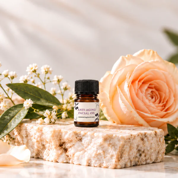 Anti-Aging Facial Oil Sample on a stone pedestal with a rose in the background