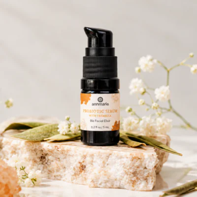 Probiotic Serum With Tremella on a stone pedestal with a white flower in the background